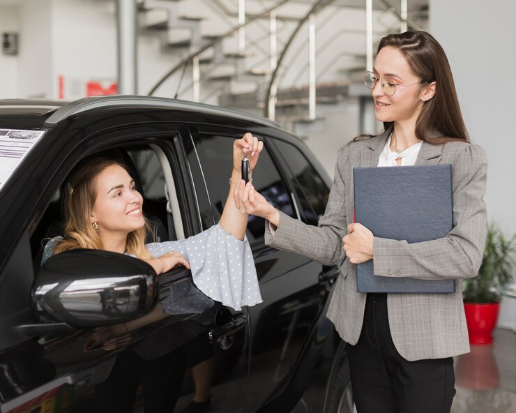 blonde woman taking keys from car dealer 23 2148384910